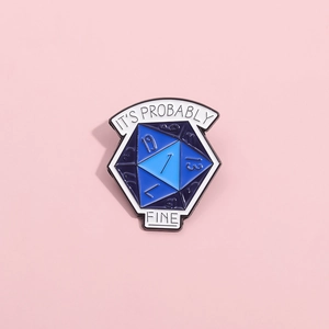 Macro view of blue D20 enamel pin with IT'S PROBABLY FINE text on a pink surface