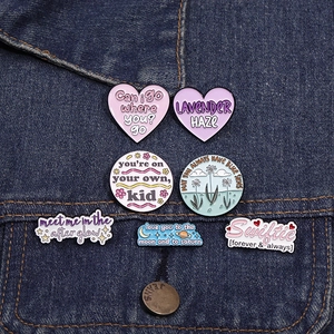 Set of 7 romantic enamel pins with moon and saturn designs on blue denim jacket