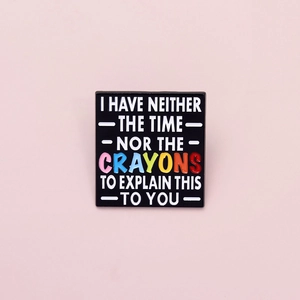 Detailed macro view of a square enamel pin with witty quote and colorful crayon text
