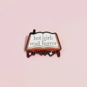 Gothic book enamel pin featuring Hot Girls Read Horror text on a pink background