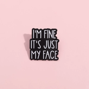 Broche en émail noir avec texte I'M FINE IT'S JUST MY FACE sur fond rose pastel
