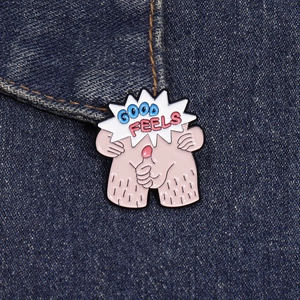 Detail of cartoon enamel pin with Good Feels text on blue denim jacket fabric