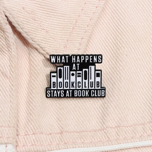 Detailed view of enamel book club pin on pink fabric featuring a witty slogan