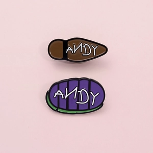 Cartoon enamel pins featuring ANDY signature on movie-inspired boots and shoe soles