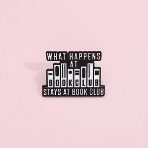 Black and white enamel book club pin badge with What Happens at Book Club stays at Book Club text