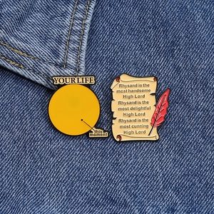 Lot de badges émaillés avec citations créatives et plume sur une veste en denim bleu
