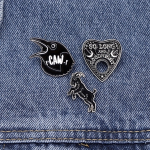 Set di 3 spille in smalto gotico con capra nera, corvo e planchette su denim