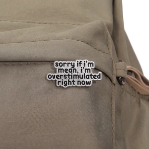 Detail einer Metallnadel mit Text sorry if I'm mean i'm overstimulated auf einer Tasche