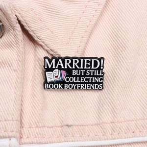 Détail macro du pin's émaillé « Book Boyfriend » sur le col d'une veste en jean rose