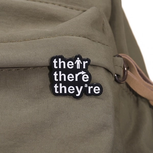 Funny grammar lesson enamel pin with Their There Theyre text on green canvas bag
