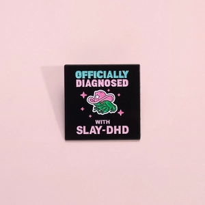 Pink cowboy frog enamel pin with Slay-DHD text on a square black metal background