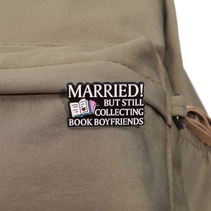 Détail du pin's émaillé pour amoureux des livres sur un sac à dos en tissu kaki