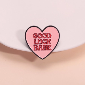 Cute pink heart enamel pin with Good Luck Babe text and black metal border for accessories