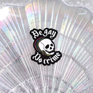 Détail du pin's émaillé crâne arc-en-ciel Be Gay Do Crime avec lettrage gothique stylé