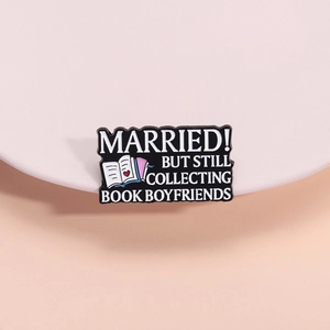 Broche en émail noir avec lettrage blanc et citation créative sur les livres