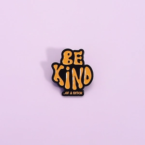 Orange 'BE KIND OF A BITCH' enamel pin with black alloy base and smooth glossy finish