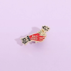 Broche en émail artistique avec main rouge tenant une rose noire et texte BAD SEED