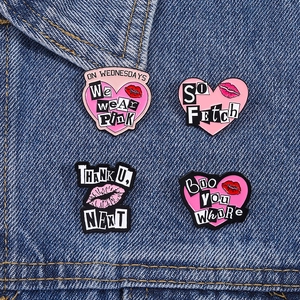 Lot de pins en émail rose avec citations pop culture sur fond en tissu denim bleu foncé