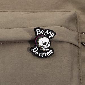 Pin's émaillé crâne arc-en-ciel avec slogan Be gay Do crime sur un sac en toile