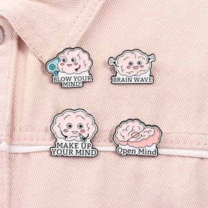 Détail de broches créatives en émail en forme de cerveau rose avec jeux de mots