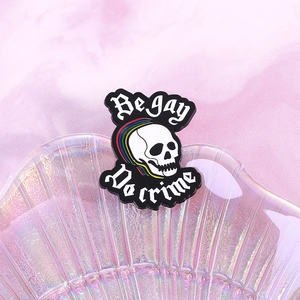 Broche en émail crâne arc-en-ciel avec texte Be Gay Do Crime sur fond nacré élégant