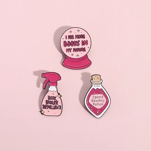 Three-piece set of pink enamel book lover pins including magic potion and crystal ball