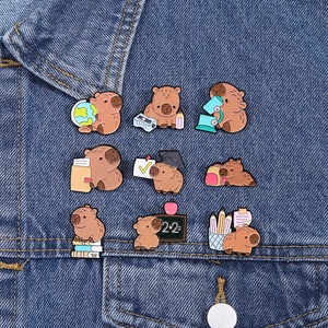 Detailed view of nine Capybara enamel pins showing cute science and math school themes
