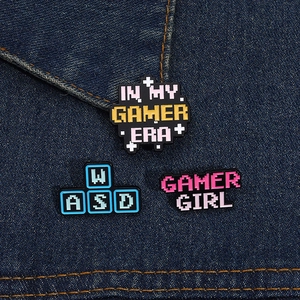 Three-piece set of pixel art gamer girl enamel pins on blue denim fabric texture