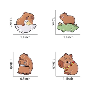 Detailed view of four cute cartoon capybara enamel pins showing sizes and varied designs