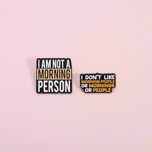 Funny black enamel pins with I Am Not A Morning Person text on a pink background