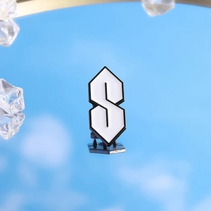 Détail du badge en métal Cool S rose et blanc avec fermeture en caoutchouc noir