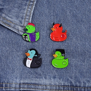Detailed view of Halloween themed enamel duck pins set on blue denim fabric