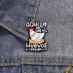 Detailed view of the cartoon hen enamel pin worn on a denim collar for decoration