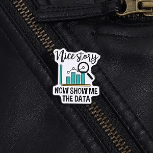 Detail of creative enamel data pin on black leather jacket with slogan Show me the data