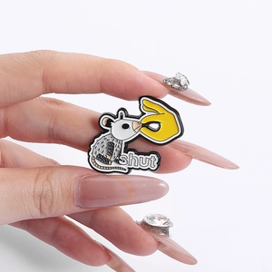 Close-up of funny grey opossum enamel pin with shut text on white background