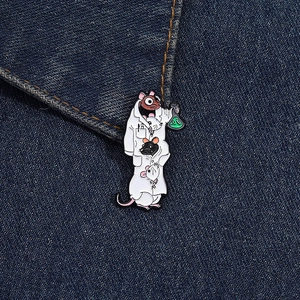 Detailed view of a cartoon lab rat scientist enamel pin on dark denim fabric background