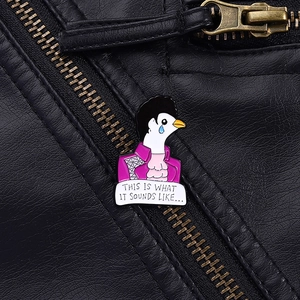 Detail of a purple crying dove enamel pin on a black leather jacket texture