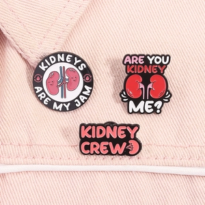 Detailed close-up of a three-piece set of pink and red kidney-themed enamel lapel pins