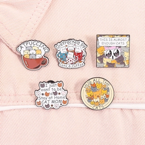 5-piece set of cute cat enamel pins with fun slogans on pink denim background