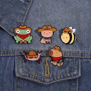 Detailed close-up of 5-piece cartoon animal enamel pins pinned on denim fabric