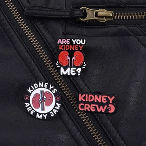 Detailed close-up of colorful kidney enamel pins styled on a black leather jacket collar