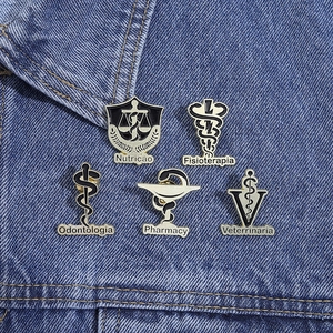 Set of five gold-plated medical enamel pins with caduceus and caduceus icons on denim