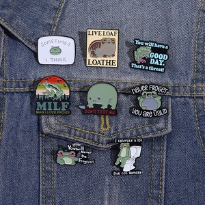 Set of 8 funny cartoon frog enamel pins on denim jacket showing creative meme designs