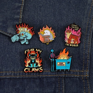 Nahaufnahme von fünf Punk-Emaille-Pins mit Totenkopf und Katze auf Denim-Stoff