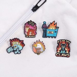 Punk enamel pin set with flaming skull and funny cat motifs on white fabric
