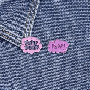Détail de broches en émail nuage rose avec texte TOTALLY VANISH sur tissu denim