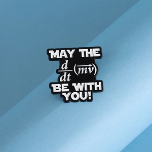 Detail of black enamel badge featuring white physics formula on textured blue background
