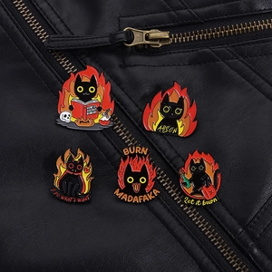 Detail of five black cat enamel pins on leather jacket showing arson and flame designs