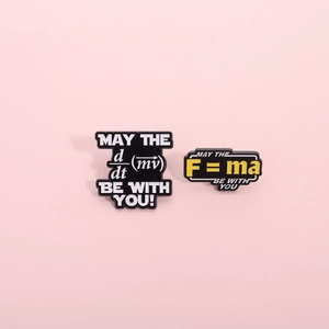 Physics enamel pins set featuring F=ma and d/dt(mv) formulas on a pink background