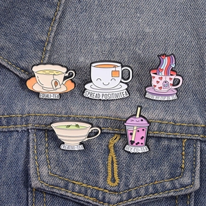 Lot de 5 broches en émail café et thé sur veste en jean avec jeux de mots et visages souriants